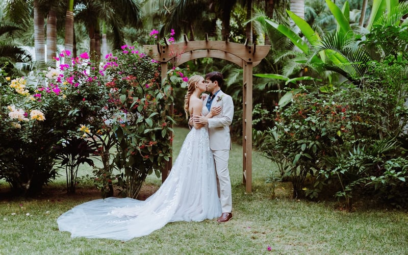 Couple kissing under garden arch