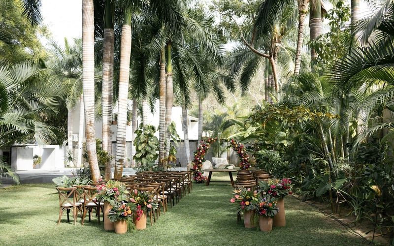 Ceremony setup with floral arrangements and palm trees