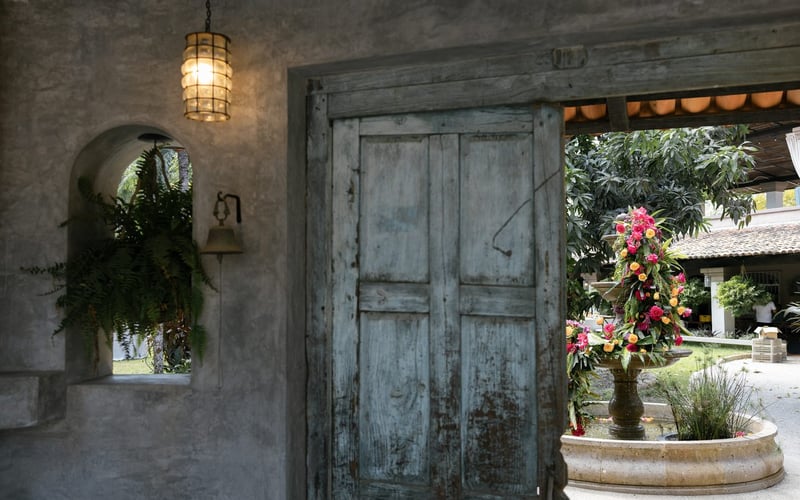 Hacienda entrance with blue door and floral fountain